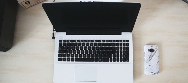 Un ordinateur portable vu de dessus sur un bureau clair.